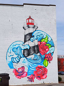 downtown mural of lighthouse with roses and water