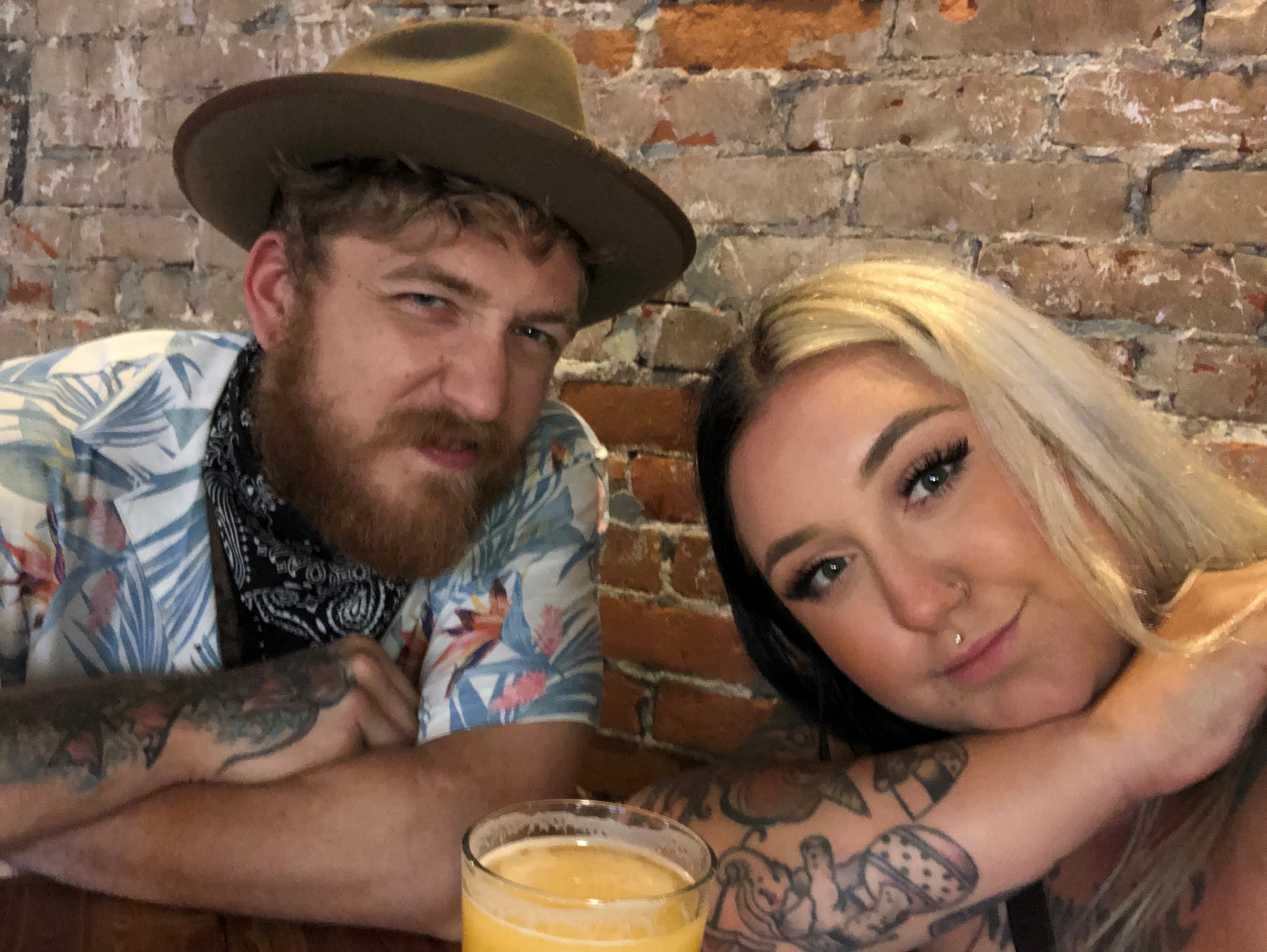 young husband and wife smiling for selfie at brewery in Elizabeth City