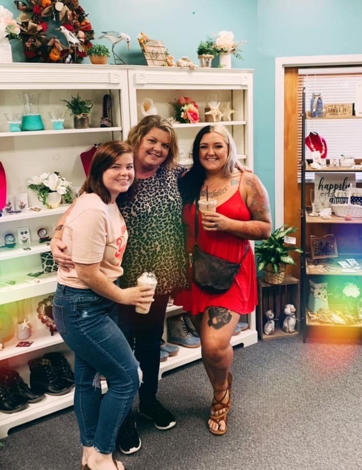 women smiling in floral shop holding coffee