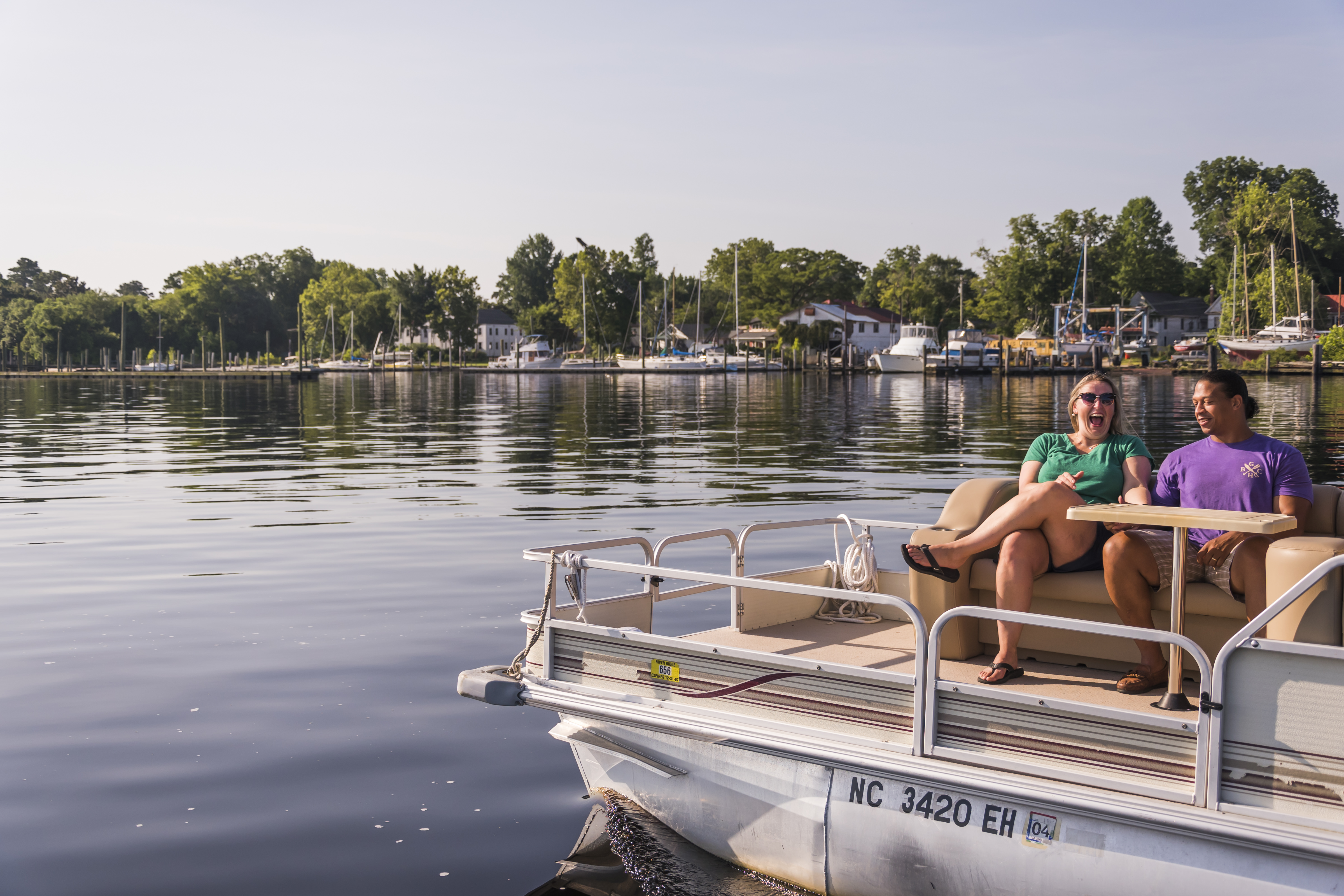 couple riding Pontoon boat on pasquotank river - Pelican Marina