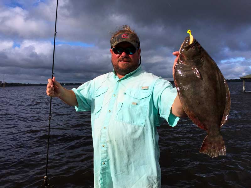 Albemarle Fishing Charters captain holding flounder