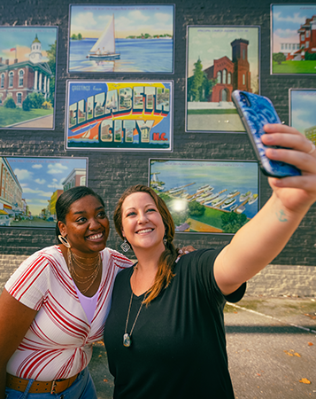 friends taking selfie with public art in downtown elizabeth ctiy