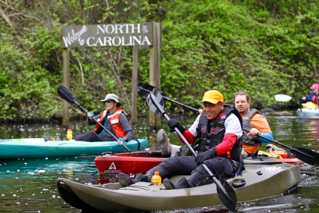 people wearing life jackets and kayaking at dismal swamp canal during fall