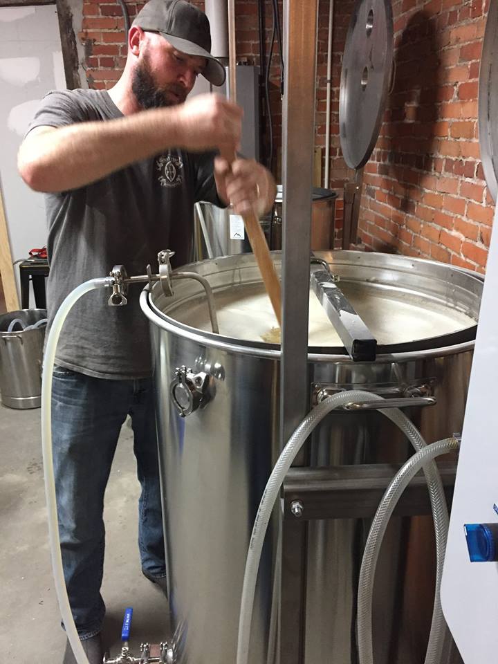 man stirring mash for beer production