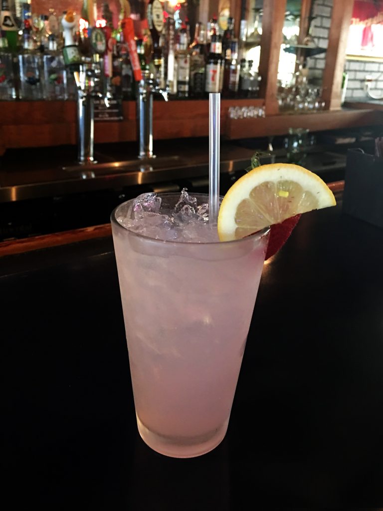drink on bar with lemon slice and straw